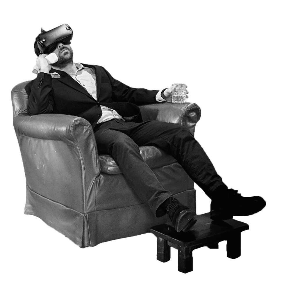 Gian Klain in a leather armchair wearing a VR headset, a glass in one hand
